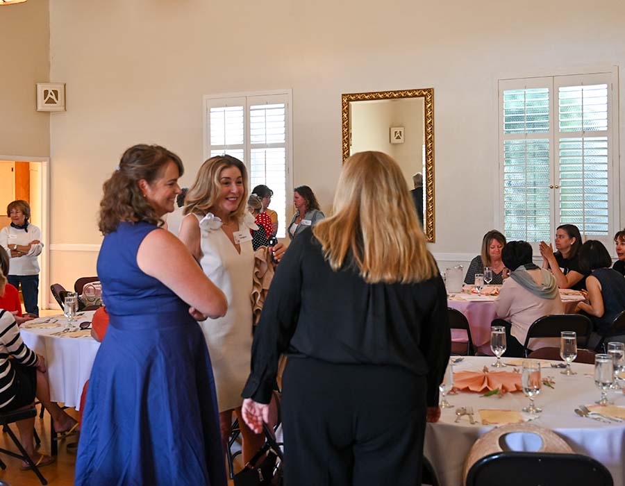 group of women standing and chatting at the luncheon